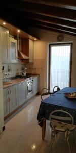 uma cozinha com uma mesa com uma toalha de mesa azul em Villetta di montagna em Foza