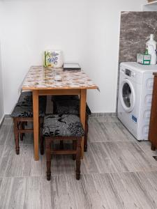 a kitchen with a table and a washing machine at Sobe Marija in Kikinda