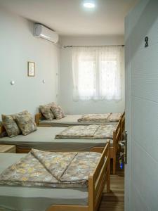 Un grupo de 4 camas en una habitación en Sobe Marija, en Kikinda