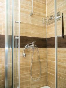 a bathroom with a shower with wooden walls at Sobe Marija in Kikinda