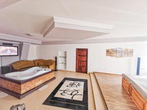 a living room with a bath tub in a room at Julianna Vendégház Étterem, Rendezvényhelyszín és Szállás 