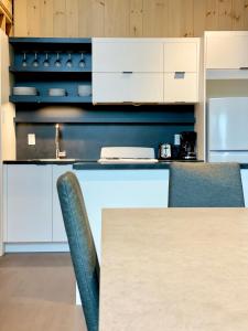 Tring-Jonction的住宿－Aventuria，厨房配有白色橱柜和桌椅