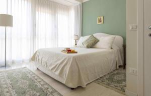 ein Schlafzimmer mit einem weißen Bett und einem Tisch darauf in der Unterkunft Casa Lazzarini luxury apartment in Pesaro