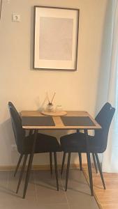 uma mesa de jantar com cadeiras e uma foto na parede em S&A apartamentai em Panevėžys