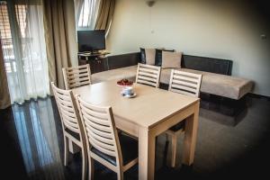 a dining room with a table and chairs and a couch at Apart Hotel Apolonia Palace in Sinemorets