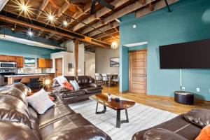 a living room with leather furniture and a flat screen tv at Railway Retreat in Downtown in Springfield