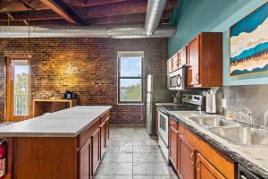 a kitchen with wooden cabinets and a brick wall at Railway Retreat in Downtown in Springfield