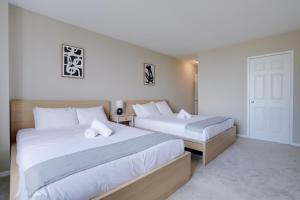 a bedroom with two beds with white sheets at Serenity in the Condo with Gym at Crystal City in Arlington