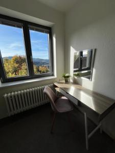 um escritório com uma secretária, uma cadeira e duas janelas em Venkovský dům Horní Bečva em Horní Bečva