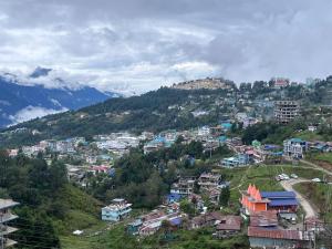 une ville sur une colline avec des maisons et des bâtiments dans l'établissement Taktserholidays, à Tawang