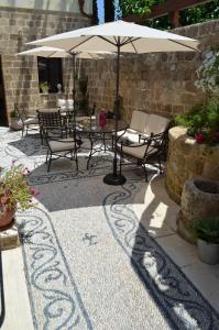 
a patio area with a table, chairs, and umbrella at Hotel Ellique in Rhodes Town
