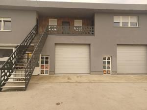 a house with two garage doors and a staircase at Apartma in Izimje