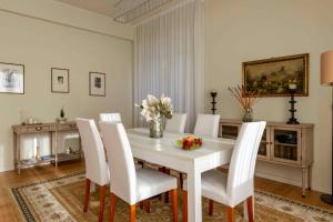 una sala da pranzo con tavolo bianco e sedie bianche di Casa Gramsci luxury apartment a Pesaro