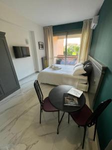 a hotel room with a bed and a table and chairs at Aurelia Green Suite in Rome +14 photos