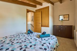 a bedroom with a bed with blue pillows on it at Finca Barralina in Campos