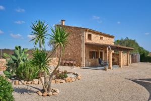 a house with a palm tree in front of it at Finca Barralina in Campos