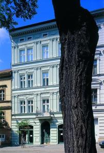 a white building with a tree in front of it at Residence Jecna in Prague