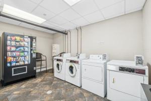 a laundry room with a refrigerator and washing machines at Luau at Sandestin Tower I & II in Destin