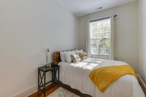 a white bedroom with a bed and a window at Richmond Home with Patio Walk to Byrd Park! in Richmond