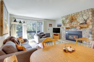 a living room with a table and a fireplace at Cozy Condo with Balcony - Near Big Sky Resort! in Big Sky