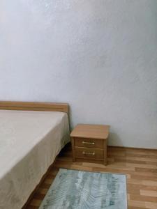 Zimmer mit 2 Betten und einem Holztisch in der Unterkunft Caspian breeze in Aqtau