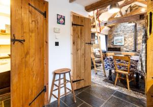 a room with a wooden door and a stool at Bwthyn Capten - a charming cottage for up to 6 in Newport Pembrokeshire