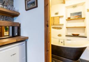 a kitchen with a sink and a microwave at Bwthyn Capten - a charming cottage for up to 6 in Newport Pembrokeshire