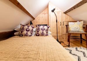 a bedroom with a bed and a lamp and a chair at Bwthyn Capten - a charming cottage for up to 6 in Newport Pembrokeshire