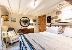 a bedroom with a bed and a chair at Bwthyn Capten - a charming cottage for up to 6 in Newport Pembrokeshire +20 photos