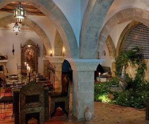 a large room with arched ceilings and a room with a table at Dar Rahaothello in Essaouira