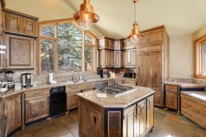 eine Küche mit Holzschränken und einem Herd mit Backofen in der Unterkunft The Gold Flake Chalet in Breckenridge + 33 Fotos