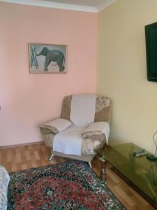 ein Wohnzimmer mit einem Stuhl und einem Tisch in der Unterkunft Caspian breeze in Aqtau