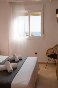 a bedroom with a bed with a window and a chair at Marina del Sol apartment by Wyndham in Fuengirola