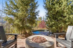 un patio trasero con piscina y 2 bancos en The Gold Flake Chalet, en Breckenridge