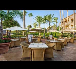 un restaurante al aire libre con mesas, sillas y sombrillas en Marina del Sol apartment by Wyndham en Fuengirola