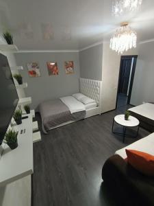 uma sala de estar com uma cama e um sofá em Квартира в центре с гостиничным сервисом. em Petropavl