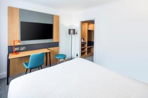 a hotel room with a bed and a tv at Holiday Inn High Wycombe M40, Jct.4, an IHG Hotel in High Wycombe