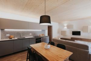 a kitchen and dining room with a table and a couch at Falcade Lodge in Falcade