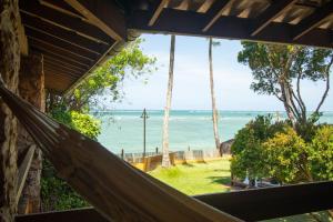 een hangmat met uitzicht op de oceaan vanuit een huis bij Pousada Minha Louca Paixão in Morro de São Paulo