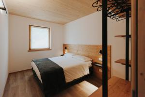 Falcade Lodge tesisinde bir odada yatak veya yataklar