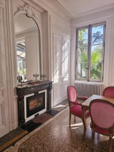 - un salon avec une cheminée, une table et des chaises dans l'établissement Château GrandClément Piscine et Parc, à Villeurbanne