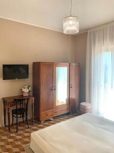een slaapkamer met een bed, een bureau en een kast bij Villa Josette in Sant'Egidio del Monte Albino