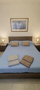 a blue bed with two towels on top of it at Casa Ricci in Acilia