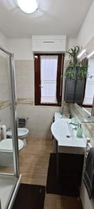 een badkamer met 2 wastafels en 2 toiletten bij Casa Ricci in Acilia