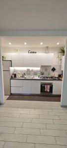 a kitchen with white cabinets and a counter top at Casa Ricci in Acilia