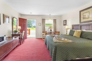 Dormitorio con cama, escritorio y TV en Blue Spruce Inn & Suites, en Valatie