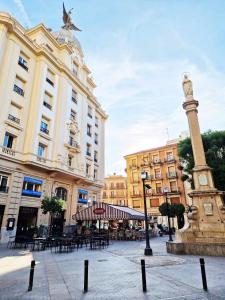 ein Gebäude mit einer Statue in der Mitte einer Straße in der Unterkunft Alojamientos Fenix in Murcia