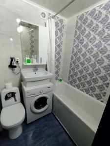 uma casa de banho com um lavatório, um WC e uma banheira em Квартира в центре с гостиничным сервисом. em Petropavl