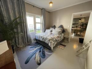 ein Schlafzimmer mit einem Bett mit einem Federwandbild auf dem Boden in der Unterkunft Villa Songo, Estuary Country Estate, INVERTER & RENOVATED in Port Edward