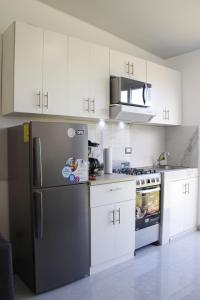a kitchen with white cabinets and a black refrigerator at Residencial Privada Nueva San miguel, casa Flores in San Miguel